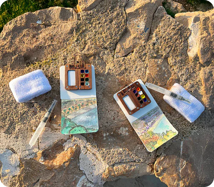 Dos kits de acuarelas portátiles Tobio sobre unas rocas