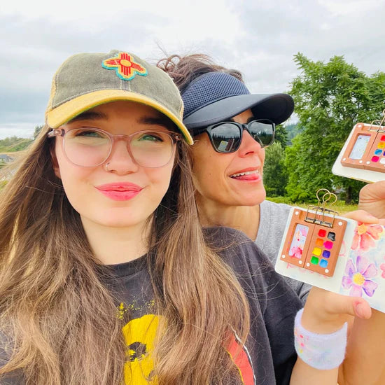 Sofía y su hija mostrando sus kits de acuarela
